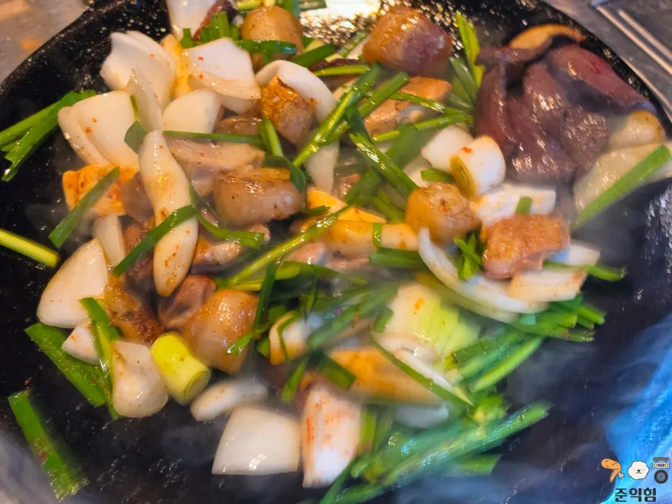 Staff mixing and cooking the gopchang on the hot plate