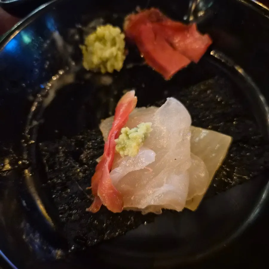 Sashimi topped with wasabi and side dishes