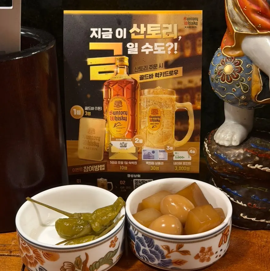 Complimentary dishes of pickled peppers and braised quail eggs with konjac