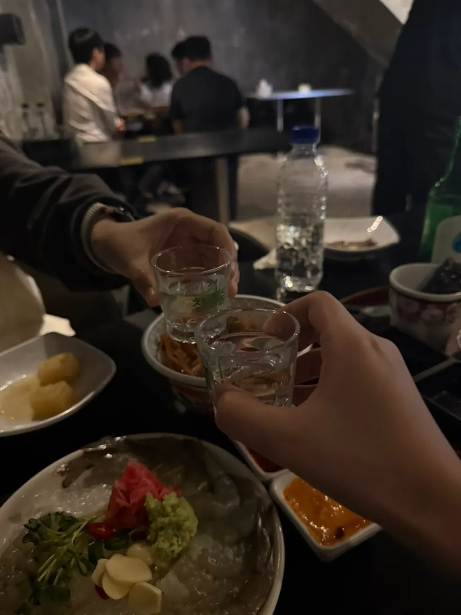 A shot of soju alongside the side dishes