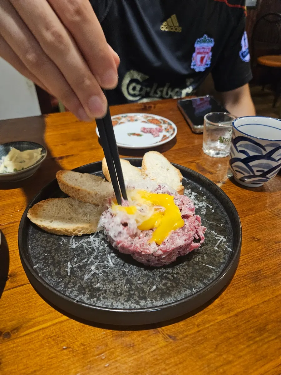 Truffle hanwoo yukhoe topped with egg yolk, served with bread