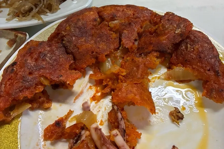 Plate of kimchi jeon with a piece removed