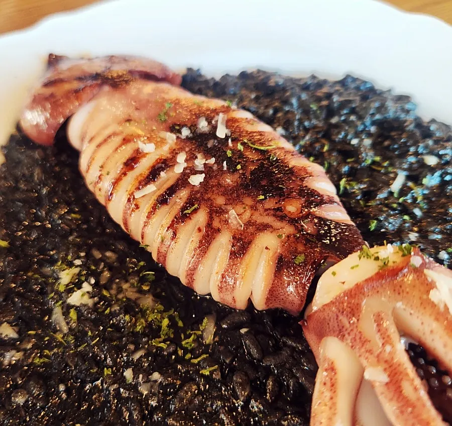 Squid ink risotto topped with squid