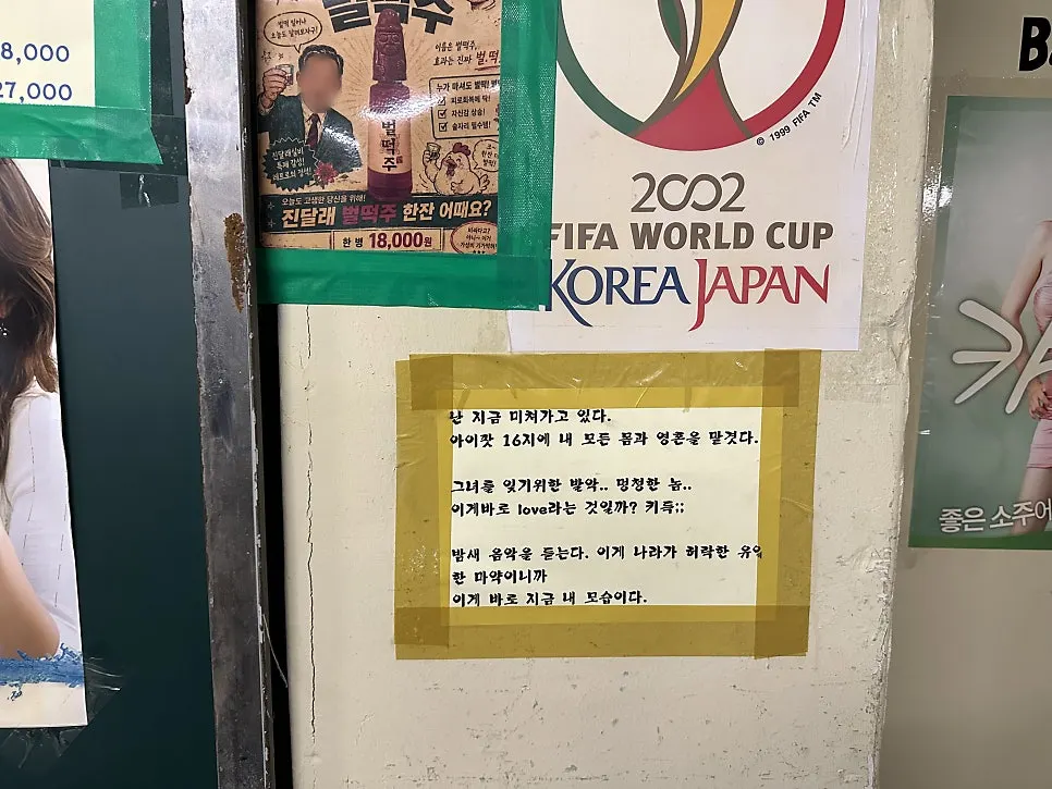 손님 사인과 빈티지 술병이 진열된 매장 벽면