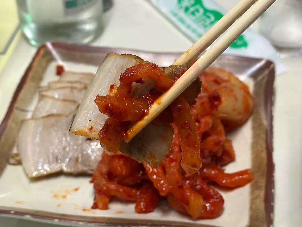 수육에 김치를 얹어 집은 젓가락 컷