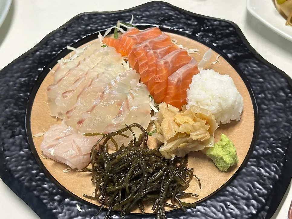 대광어와 연어 숙성회가 담긴 검은 접시