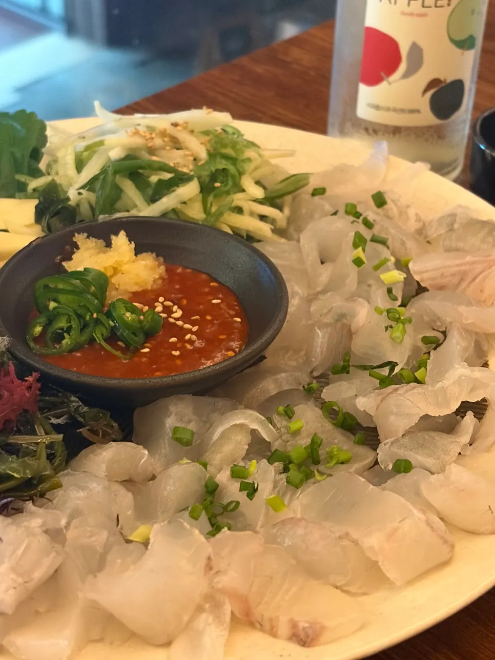 A piece of sashimi topped with washed aged kimchi