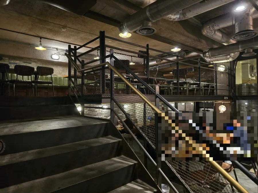 Duplex structure divided by a metal staircase with chair seating