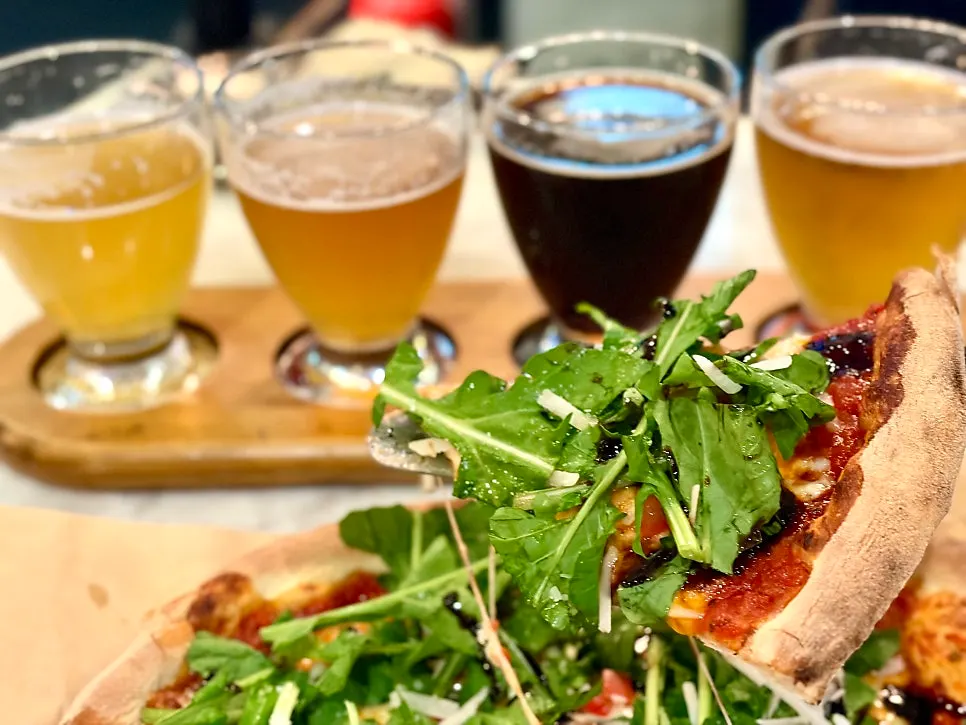 Lifting a slice of arugula pizza