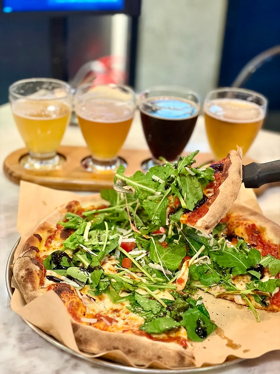 Vertical shot of cheese stretching from the arugula pizza