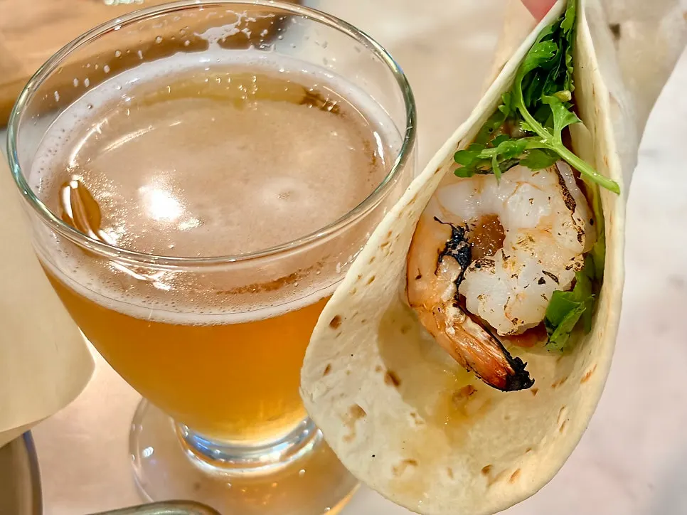Table with pizza, tacos, and craft beer together
