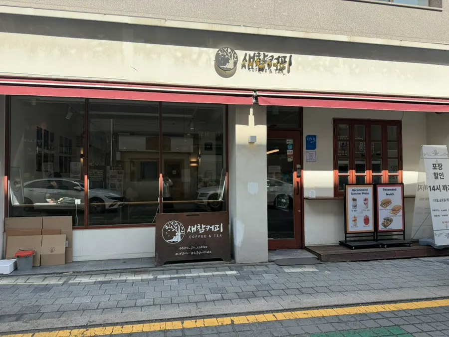 밝은 외벽에 붉은색 포인트가 들어간 새참커피 외관