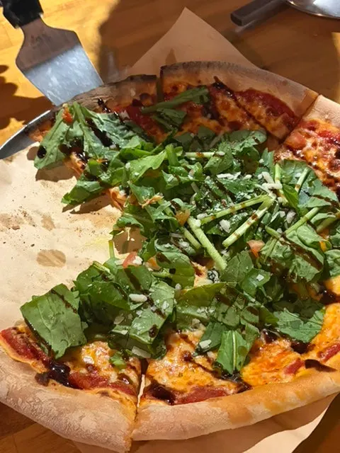 A whole pizza loaded with arugula