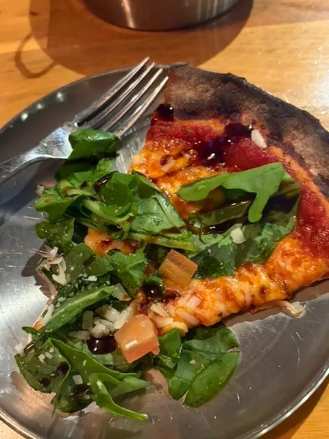 Close-up of arugula on tomato sauce and cheese