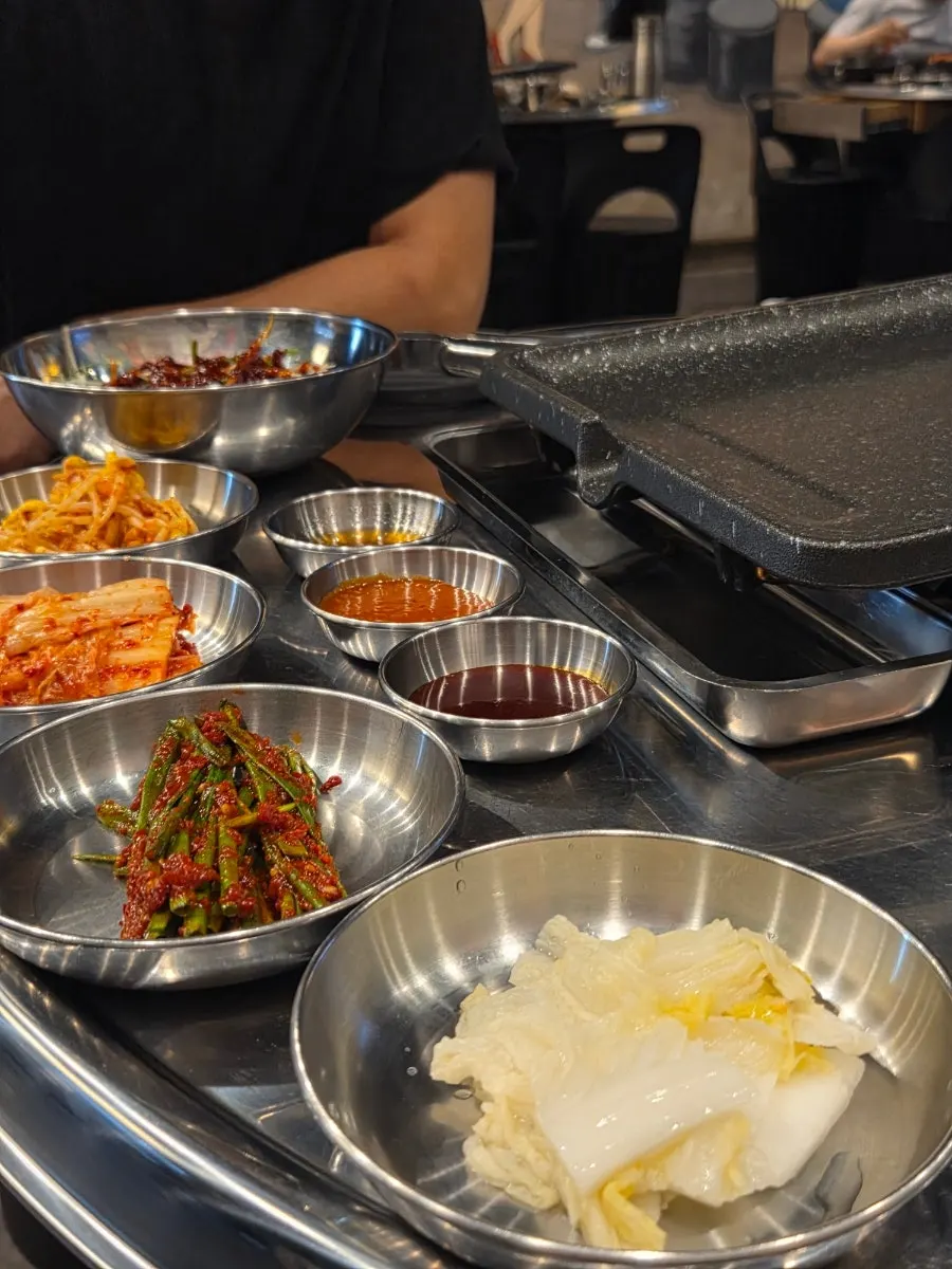 Plates of kimchi, white kimchi, and other side dishes
