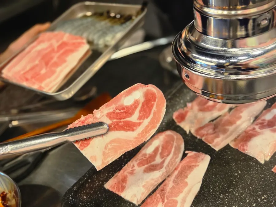 Thin naengsam pork belly slices on the grill