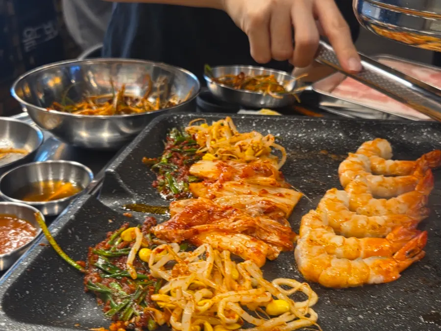 A piece of naengsam topped with grilled scallion kimchi