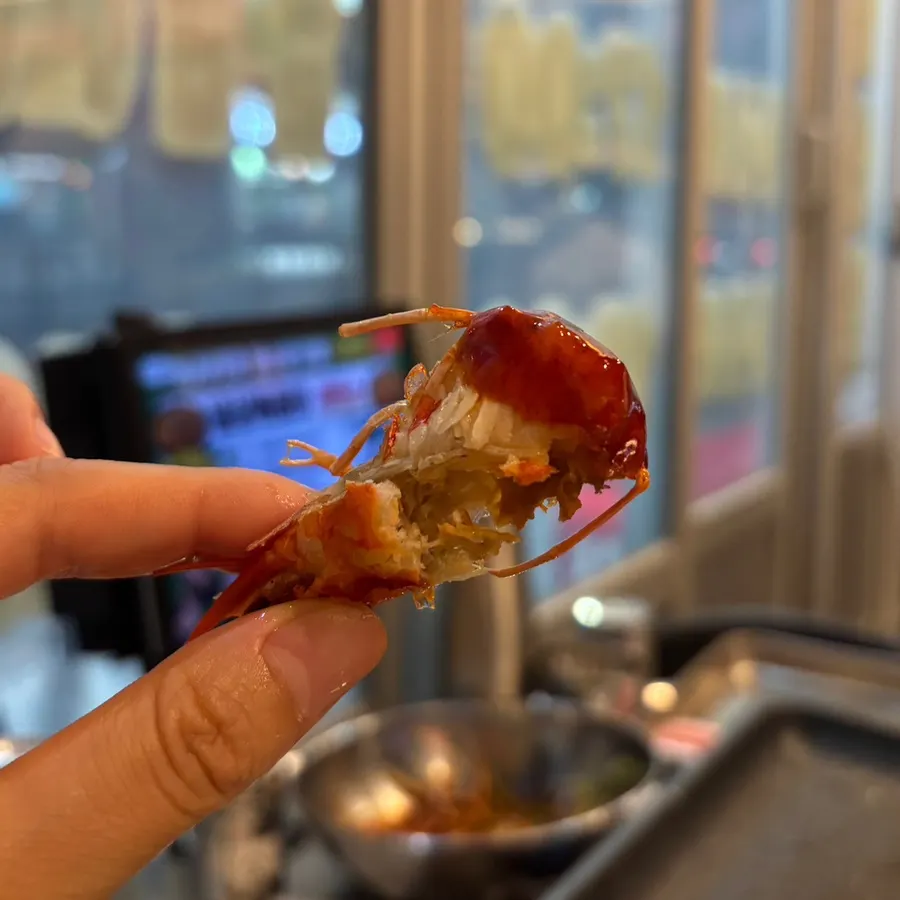 Fried shrimp head with shell removed, dipped in sauce