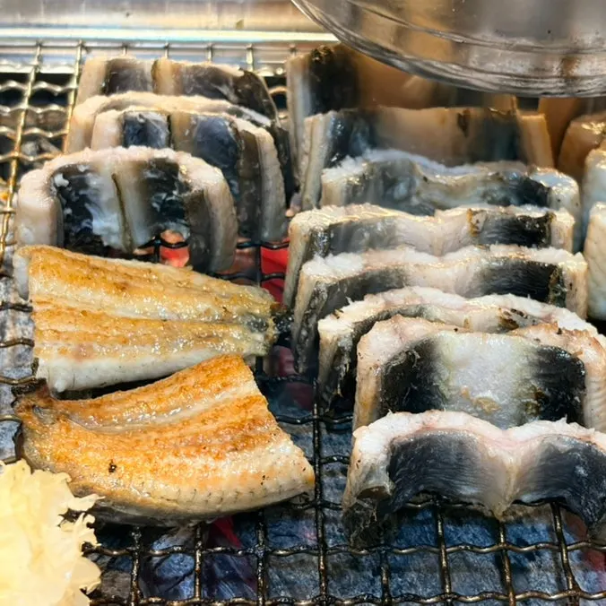 Staff grilling eel on the tabletop grill