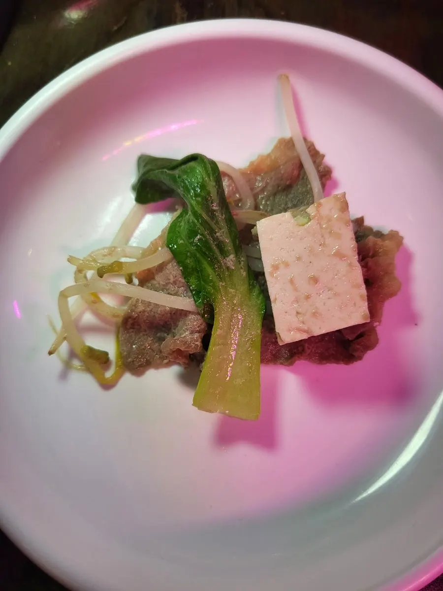 Cooked sukiyaki ingredients dipped in sauce
