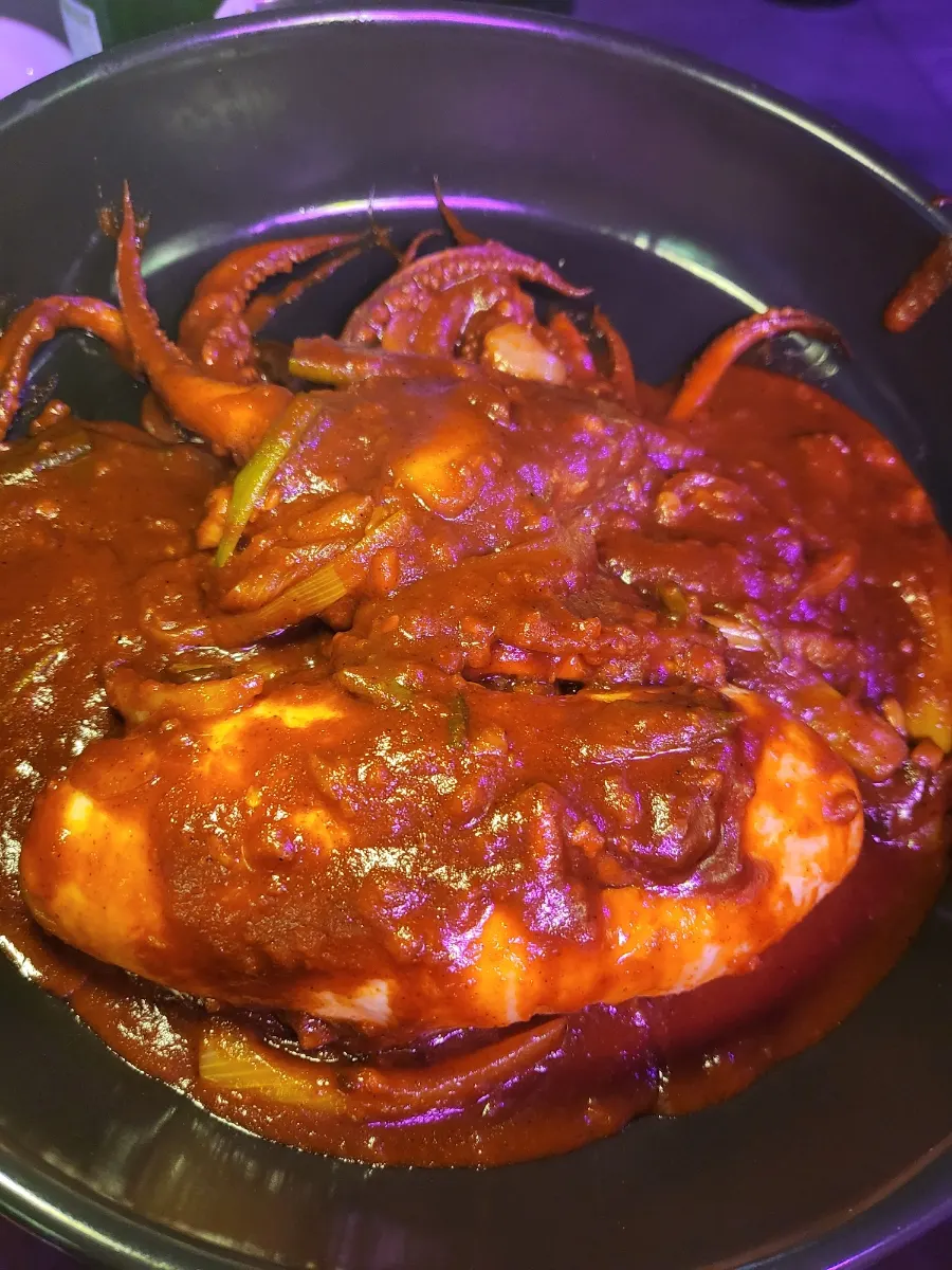 A plate of Sungan-Addictive Spicy Squid coated in red sauce