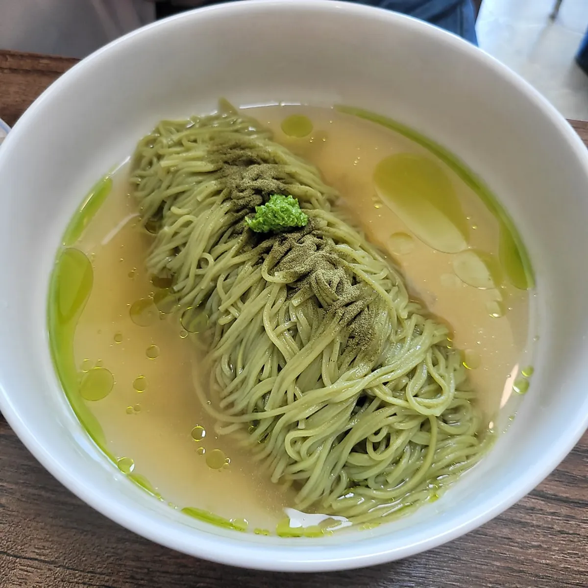 A bowl of matcha-noodle meat noodles showing the greenish noodles