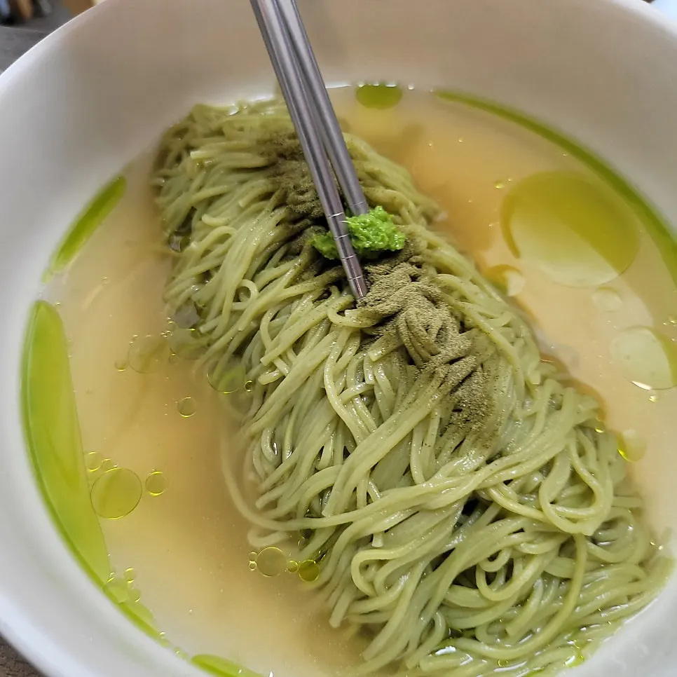 Matcha noodles submerged in warm meat broth