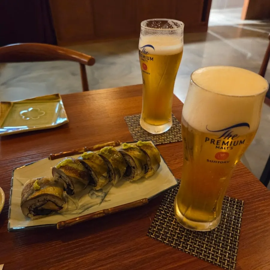 A glass of Suntory draft beer with a rich head of foam
