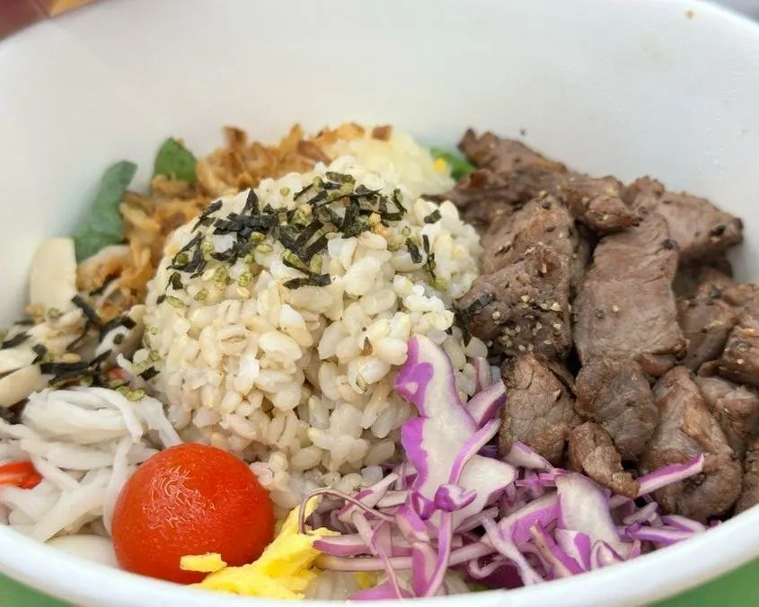 Grilled steak bibim poke in a takeout container