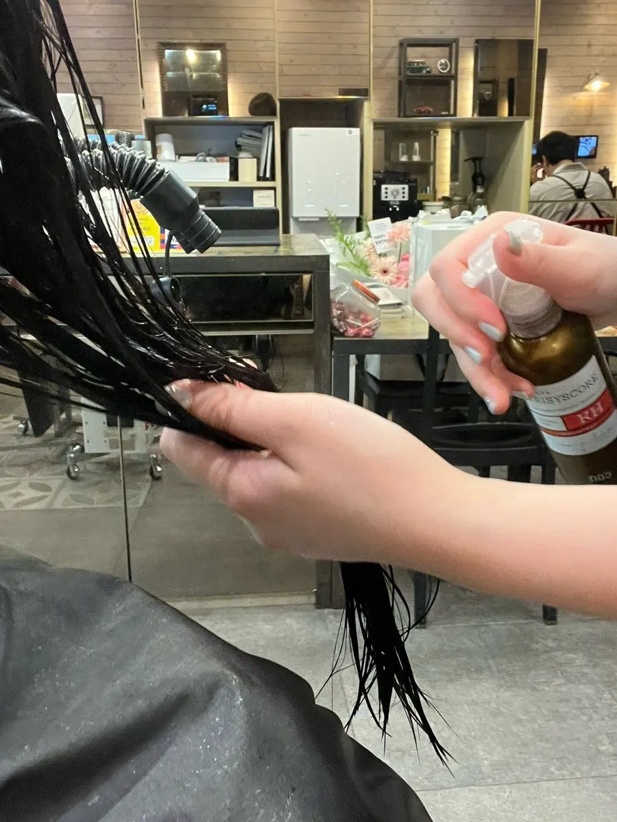 Spraying the step 3 product onto the hair