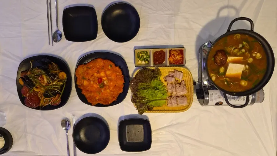 First course table with seafood stew, kimchi pancake and bossam
