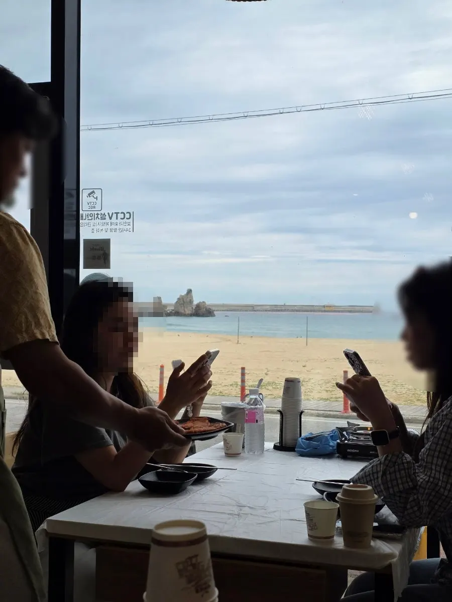 Window seats at Samcheok Bomulseom with an ocean view through the floor-to-ceiling glass