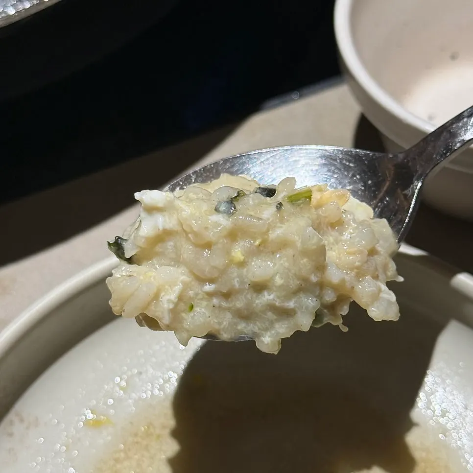 Juk topped with egg and seaweed flakes