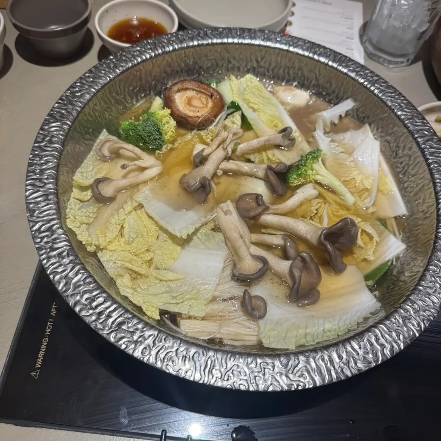 Clear broth simmering with vegetables and soy milk skin