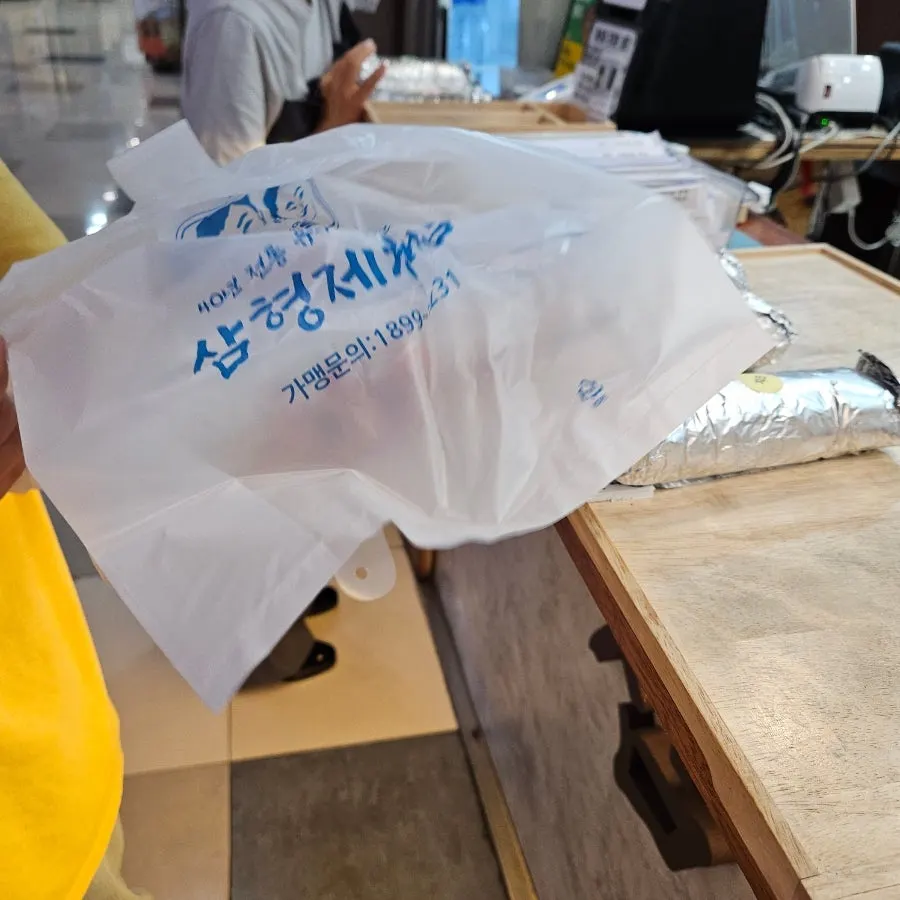 Putting ordered gimbap into a takeout bag yourself
