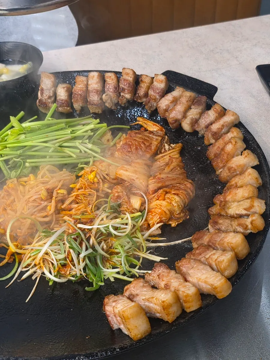 Onions and mushrooms cooking in the pot lid kimchi pork belly