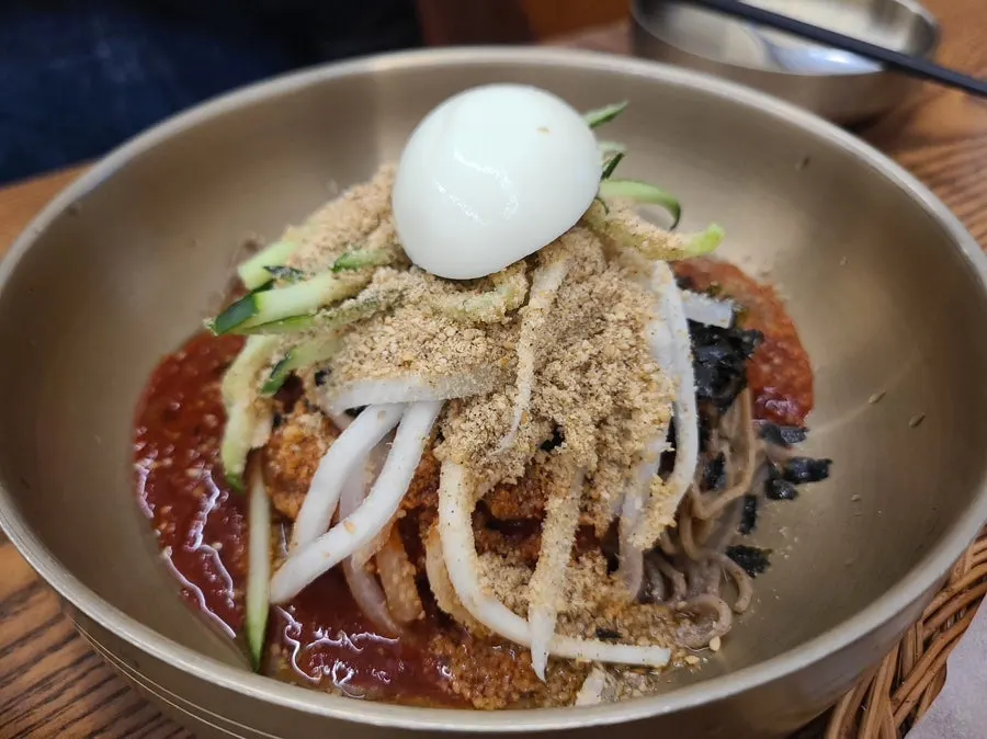 A chopstick-full of noodles lifted from the bibim makguksu
