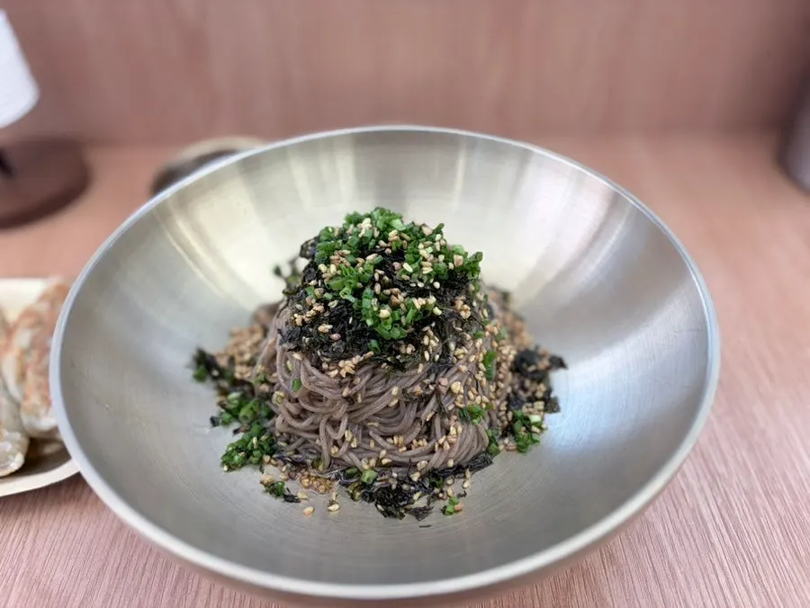 Perilla oil makguksu served in a brass bowl