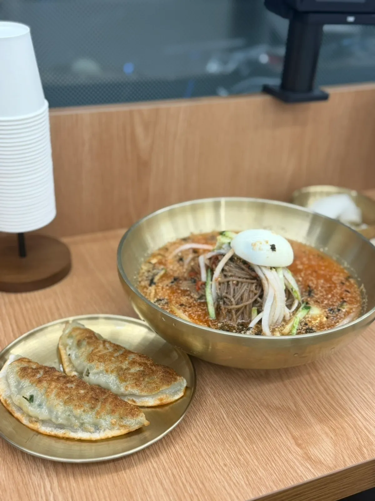 Bowl of spicy mul-makguksu topped with sesame seeds