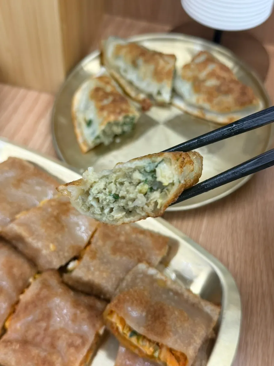Cross-section of thick buckwheat pancake full of kimchi filling
