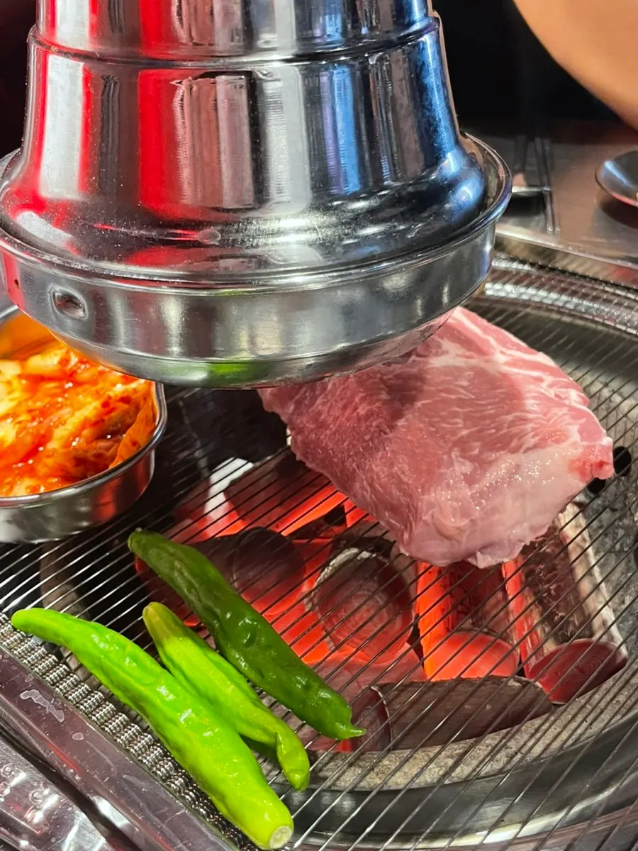 Thick-cut raw pork neck served at the table