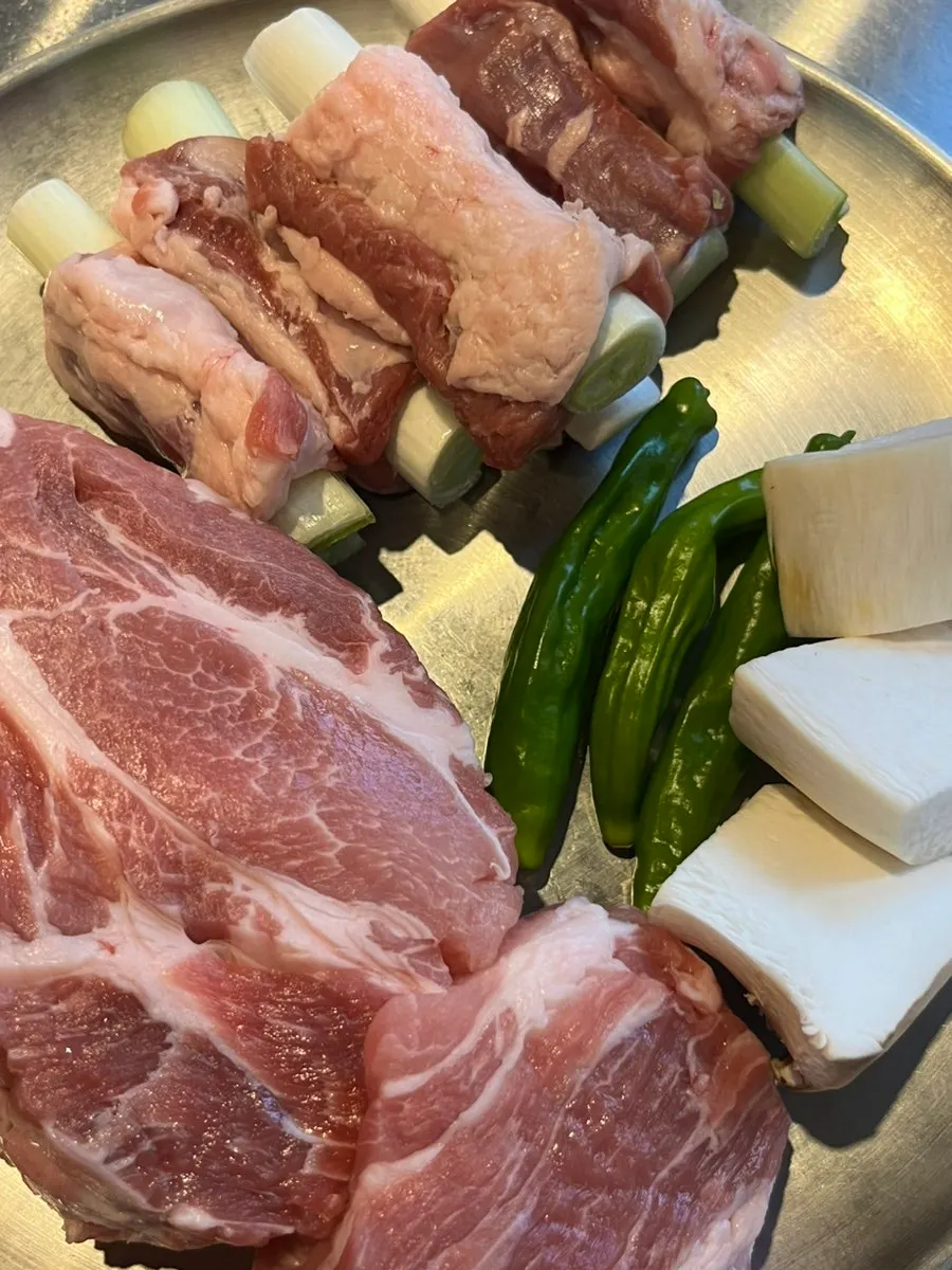 Table spread of ordered teukmoksal and whole scallion galmaegisal