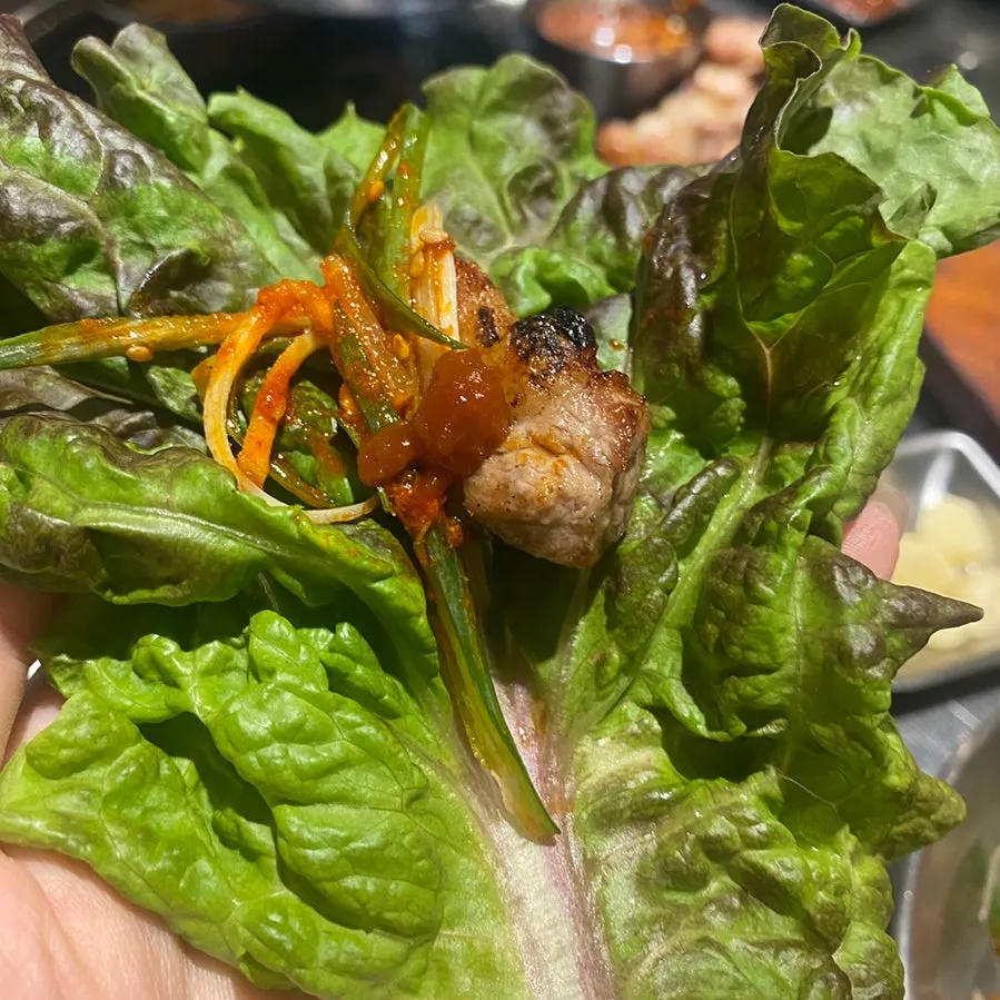 Pork belly wrap with lettuce and sliced scallions