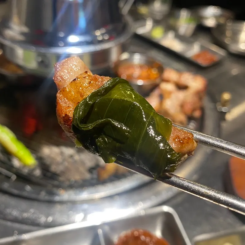 A bite of pork belly with side dishes
