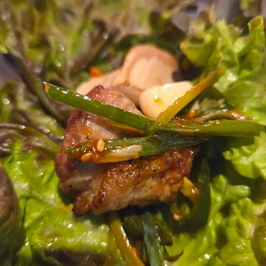 A lettuce wrap with meat and kimchi