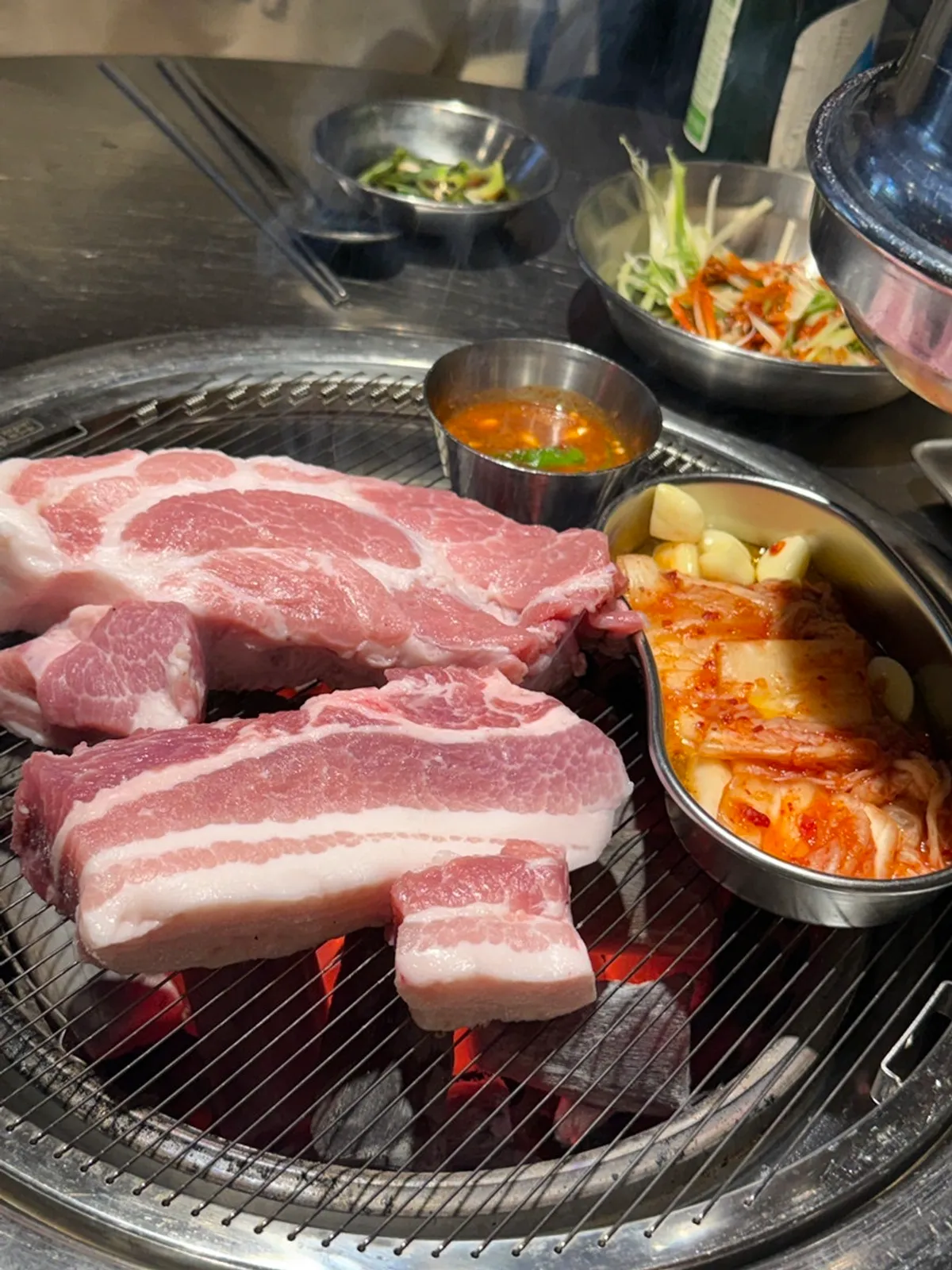 Thick aged premium pork neck plated with mushrooms and shishito peppers