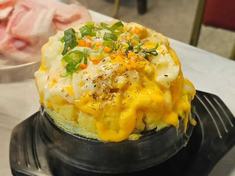 Dirty egg custard puffed up over the edge of the earthenware pot