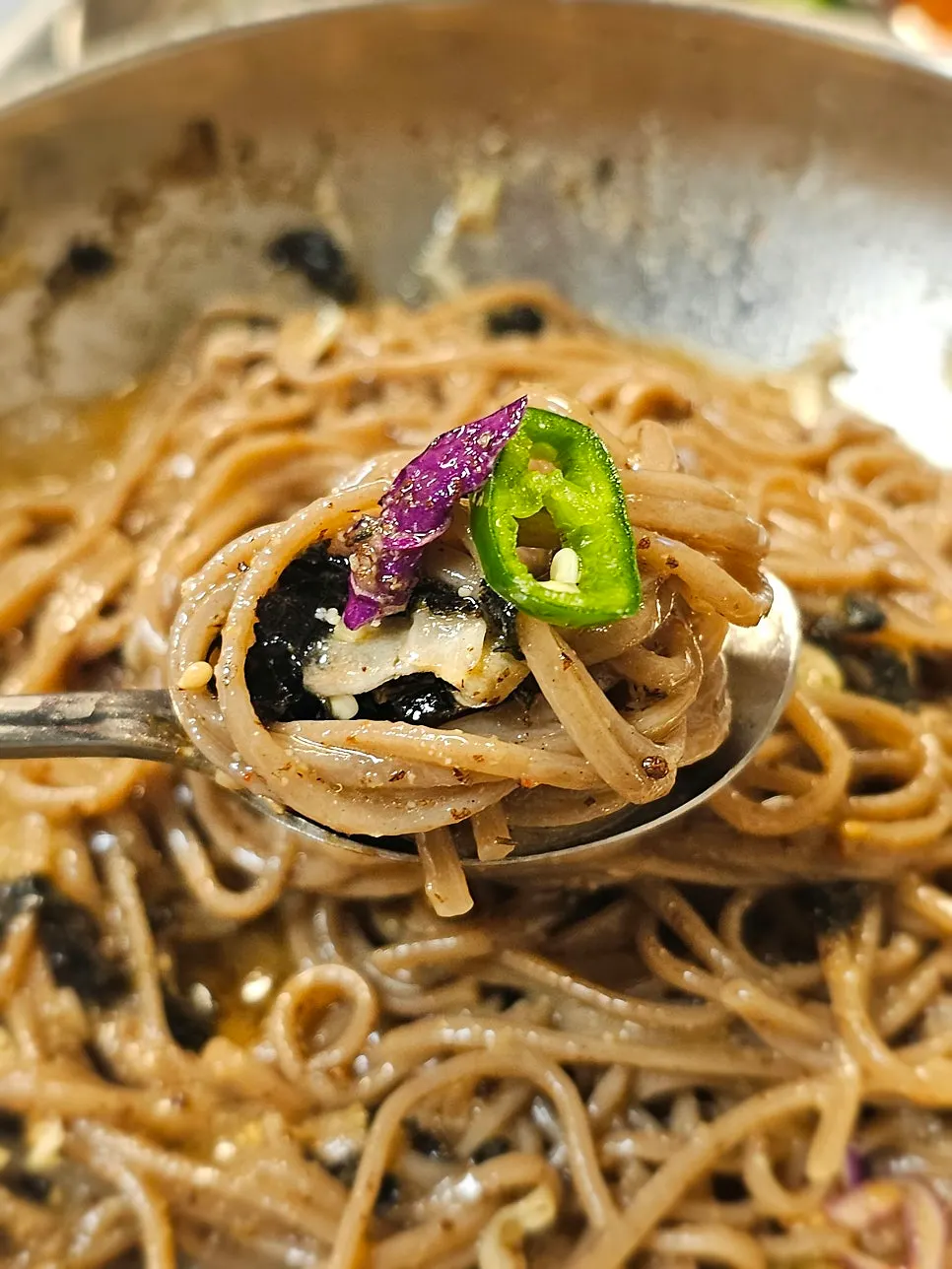 Chopsticks lifting a bundle of perilla oil cold noodles
