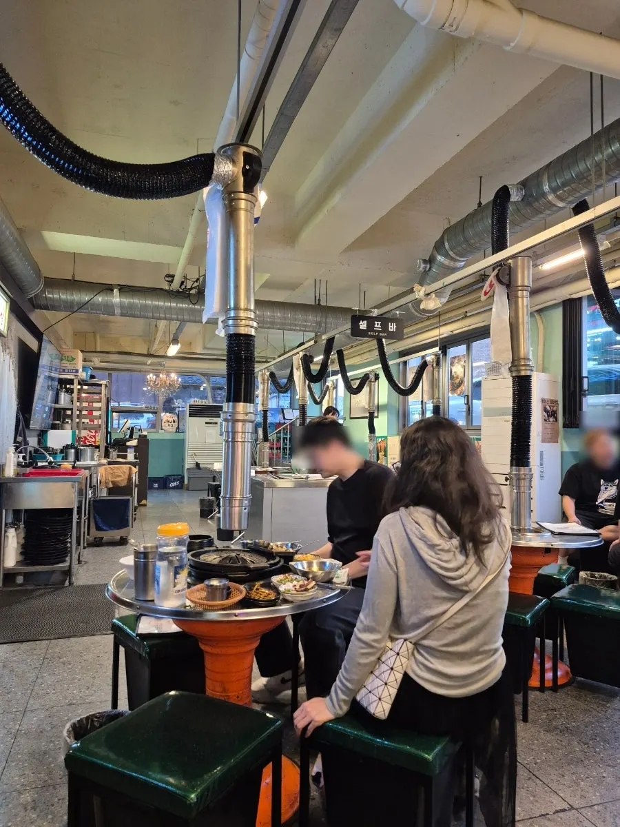 Round tables in the old-school-style dining hall at Neopttakjip Samsong Branch
