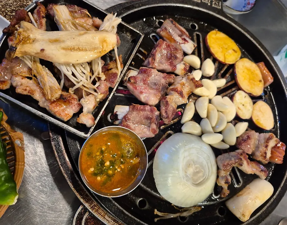 Table spread of grilled meat with side dishes